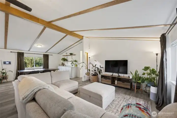 Another view of greatroom/living space from front door entrance.  New paint, trim, doors, flooring, with a vaulted ceiling.