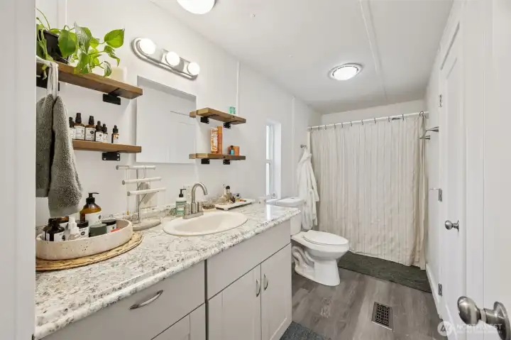 Primary full bath; new cabinetry, flooring, countertops & fixtures.