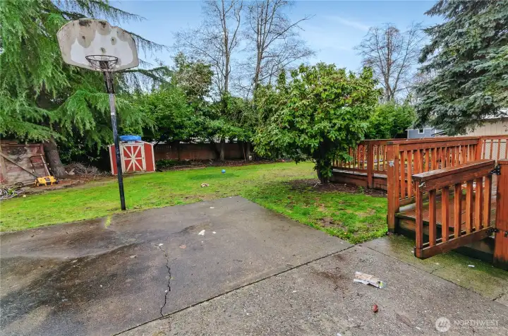 Backyard concrete patio with basketball hoop