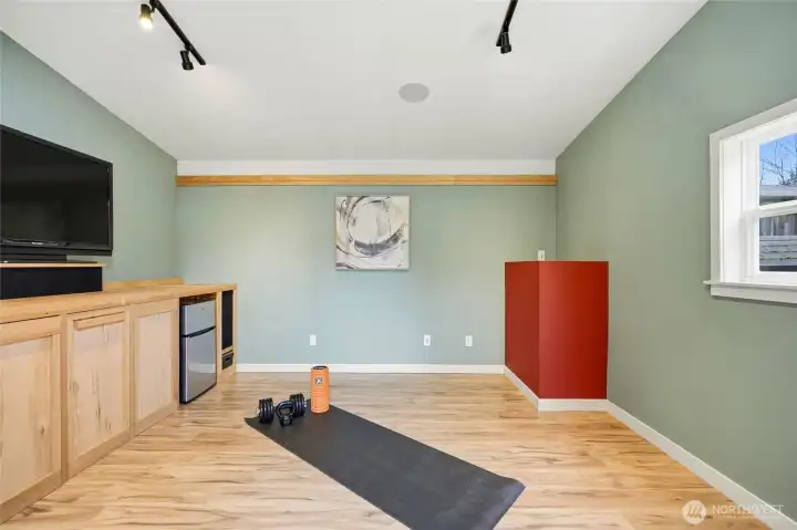Or how about a home gym? With built in speakers, a wall of cabinetry, and a TV and mini fridge that stay, the whole family will want to claim this space!