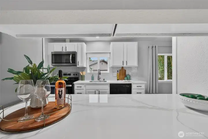 The pass-through window keeps the living area and kitchen seamlessly connected—perfect for easy conversation, shared moments, and effortless entertaining.