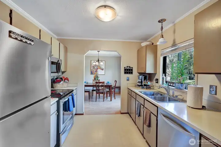 Galley style kitchen has modern stainless-steel appliance for your convenience. Deep, double stainless-steel sink has newer faucet etc.