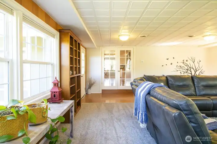 The french doors open up to the cozy living room with NEW windows (west facing).