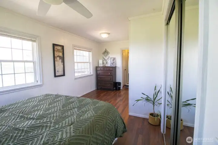 Featuring mirrored closet doors, hardwood floors & built-in shelving in closets