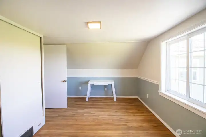 Upper-level west facing room/bedroom in the original portion of the home (1881!) with charming sloped ceilings and fresh paint