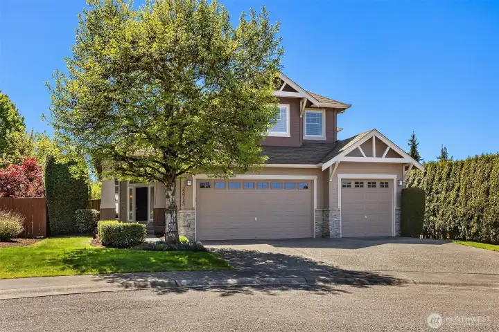Attractive exterior showcases a neutral palette with stone detailing, complemented by a 3-car garage and generous driveway parking.