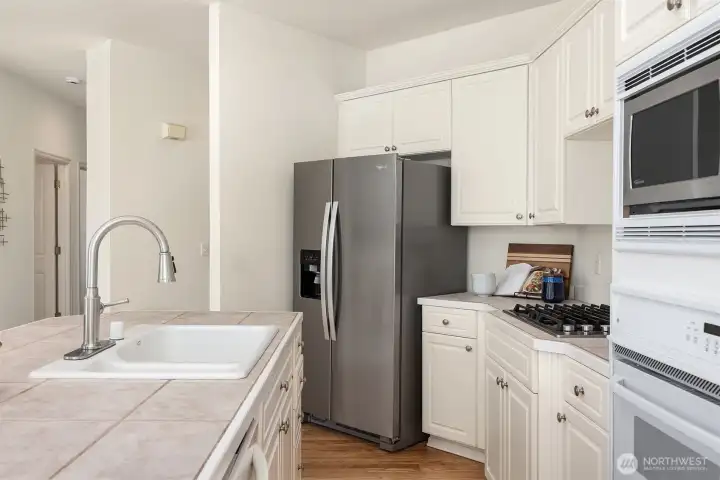 Enjoy the convenience of a kitchen equipped with a newer stove and refrigerator.