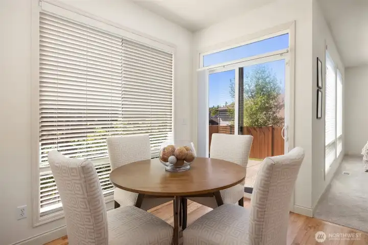 The kitchen offers flexible eating spaces, including this cozy breakfast nook and island seating. Plus, easy access to the backyard through the sliding glass door.