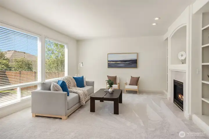 Sunlight pours through nearly floor-to-ceiling windows in the living room.