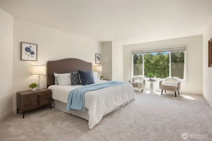 Retreat to the spacious primary bedroom, where expansive windows and beautiful architectural cutouts create a bright, relaxing space.