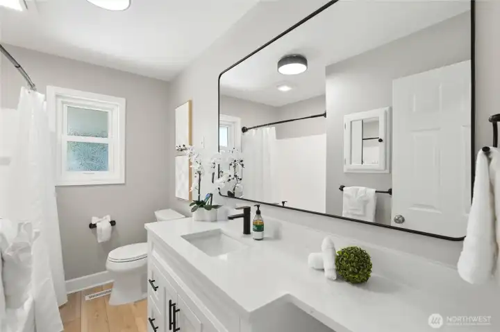 The bathroom has been fully renovated with modern finishes.  Quartz countertops add a clean and elevated touch.