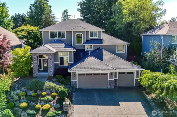 Stunning curb appeal welcomes you home with stone accents, mature landscaping, and a spacious three-car garage.