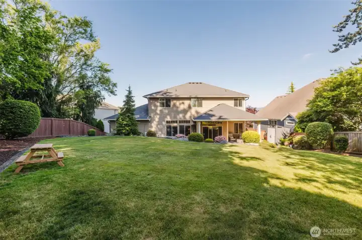 A private outdoor retreat featuring lush lawn, mature trees, and beautifully landscaped grounds designed for year-round enjoyment.