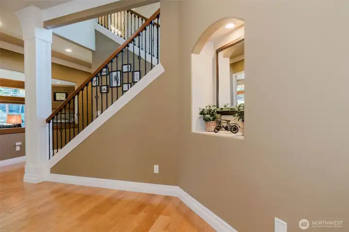 Custom architectural details and elegant iron balusters create a striking focal point at the heart of the home.