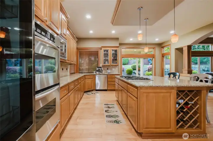 The heart of the home—an expansive chef's kitchen featuring abundant cabinetry, granite countertops, double ovens, and a large center island.