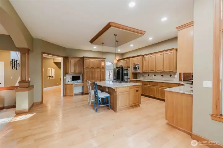 Granite surfaces, custom cabinetry, double ovens, gas cooktop, and extensive storage make this a true chef's kitchen.