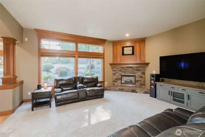 The inviting great room offers custom built-ins, a beautiful stone fireplace, and large windows overlooking the private backyard.