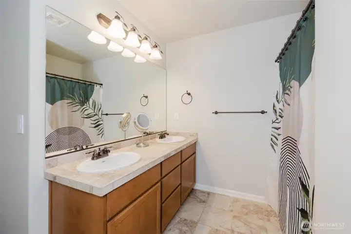 Designed to comfortably serve the upper level, this full bath features dual sinks, ample storage, and plenty of space for busy mornings.