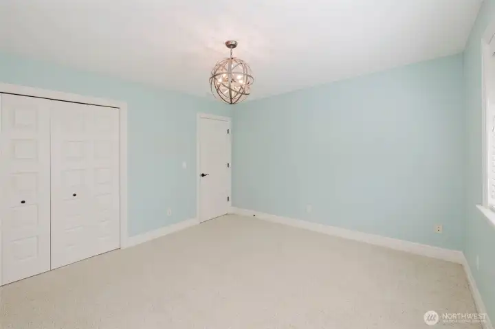 A cheerful and versatile bedroom offering comfortable living space with ample storage and a fresh, airy feel.