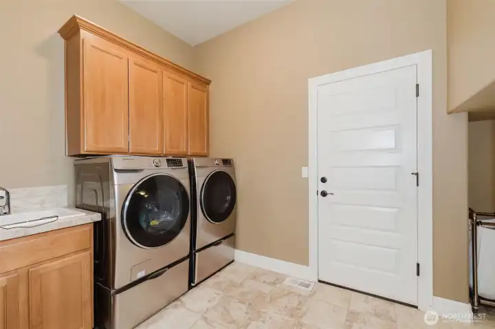 Function meets convenience in this well-appointed laundry room with built-in storage, utility sink, and room for additional organization.