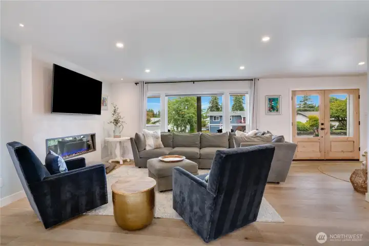 The great room anchors the main floor — linear electric fireplace, oversized picture windows, and French doors to the backyard create seamless indoor-outdoor flow. The great room anchors the main floor — linear electric fireplace, oversized picture windows, and French doors to the backyard create seamless indoor-outdoor flow.
