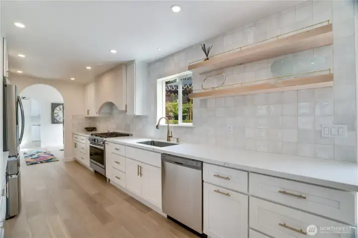 The kitchen’s arched range hood, custom cabinetry, and stainless appliance suite deliver a restaurant-quality cooking environment. The kitchen’s arched range hood, custom cabinetry, and stainless appliance suite deliver a restaurant-quality cooking environment.