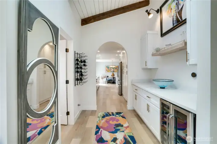 Shiplap ceiling, exposed beam, built-in wine rack, beverage refrigerator, and quartz butler’s counter — all framing a graceful arch that opens to the kitchen and dining beyond. This corridor is the design soul of the home. Shiplap ceiling, exposed beam, built-in wine rack, beverage refrigerator, and quartz butler’s counter — all framing a graceful arch that opens to the kitchen and dining beyond. This corridor is the design soul of the home.