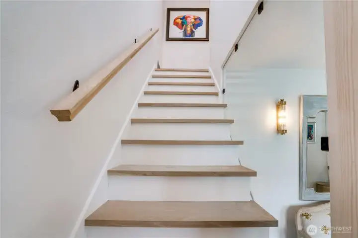 The stair landing reveals what photos can’t fully capture — double-height ceiling, clerestory window flooding natural light, statement lantern pendant, and glass panel railing. The stair landing reveals what photos can’t fully capture — double-height ceiling, clerestory window flooding natural light, statement lantern pendant, and glass panel railing.