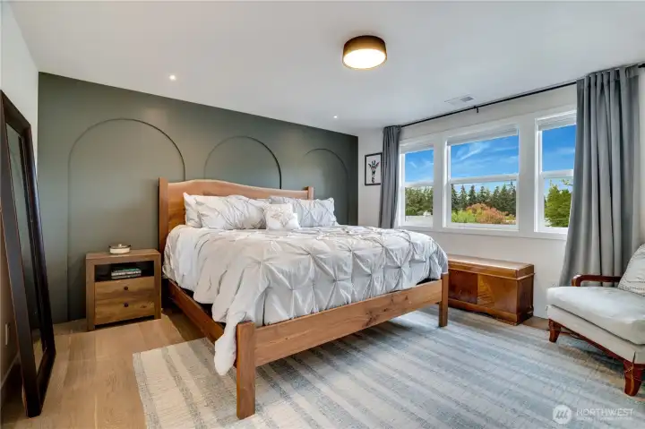 The primary suite features a designer arched accent wall, engineered hardwood, oversized windows with tree views, and a spa-caliber en suite. The primary suite features a designer arched accent wall, engineered hardwood, oversized windows with tree views, and a spa-caliber en suite.