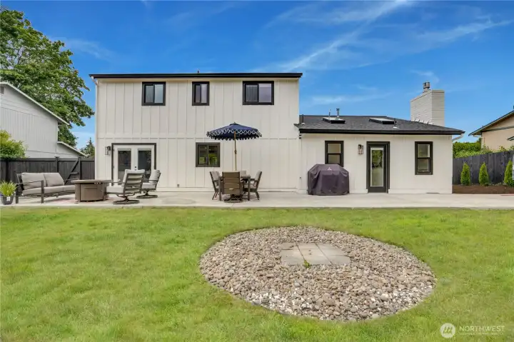 The rear of the home is as polished as the front — new French doors, expansive concrete patio, and a fully fenced yard designed for Pacific Northwest outdoor living. The rear of the home is as polished as the front — new French doors, expansive concrete patio, and a fully fenced yard designed for Pacific Northwest outdoor living.