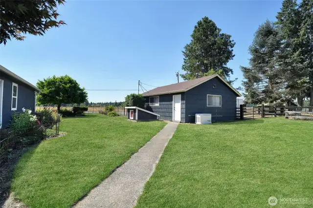 Rear of garage with location of wired generator and well house, RV parking with 30 amp hookup on west side of garage, grass has been retouched