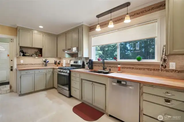 Kitchen with butcher block counters, large window for natural lighting, stainless steel appliances that are less than 3 years old