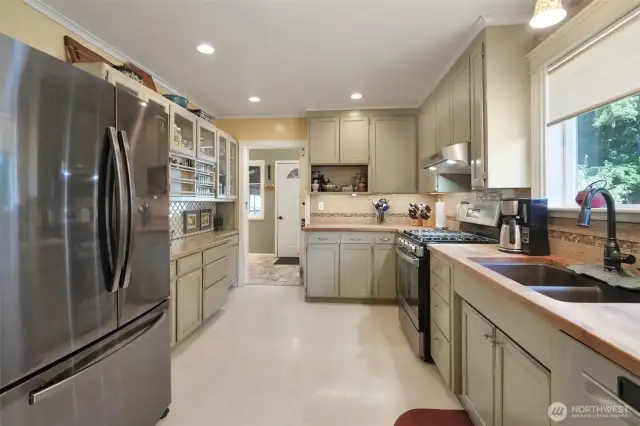 Kitchen with butcher block counters, spice rack, stainless steel appliances that are less than 3 years old