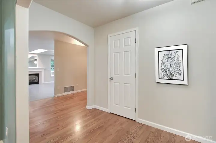 Entry hallway toward family room, powder room is the door to your right.