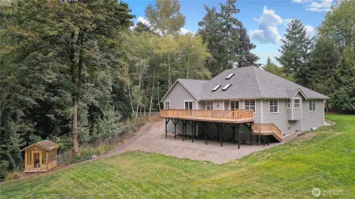 Drone view of the rear of the home, love the huge deck, glorious yard and lovely greenhouse to your left.