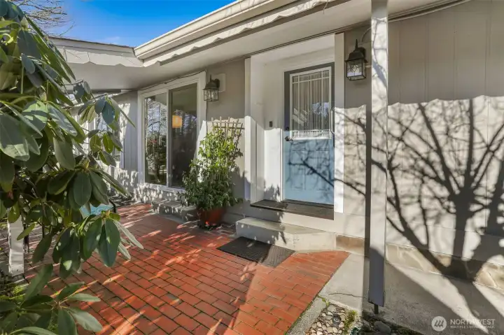 Covered front porch entry and patio overlooking the community greenbelt with trail access