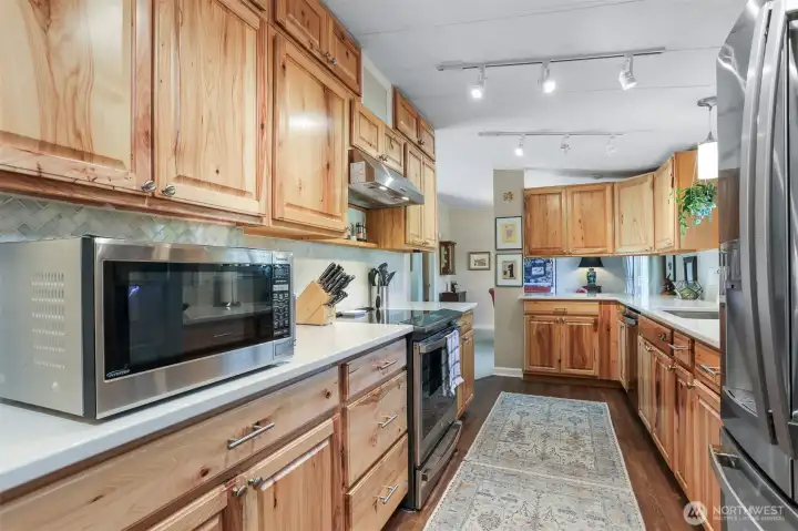 Remodeled kitchen features Hickory cabinets, quartz counters, LVP floors, GE cafe stainless appliances and an eating bar to the dining room.