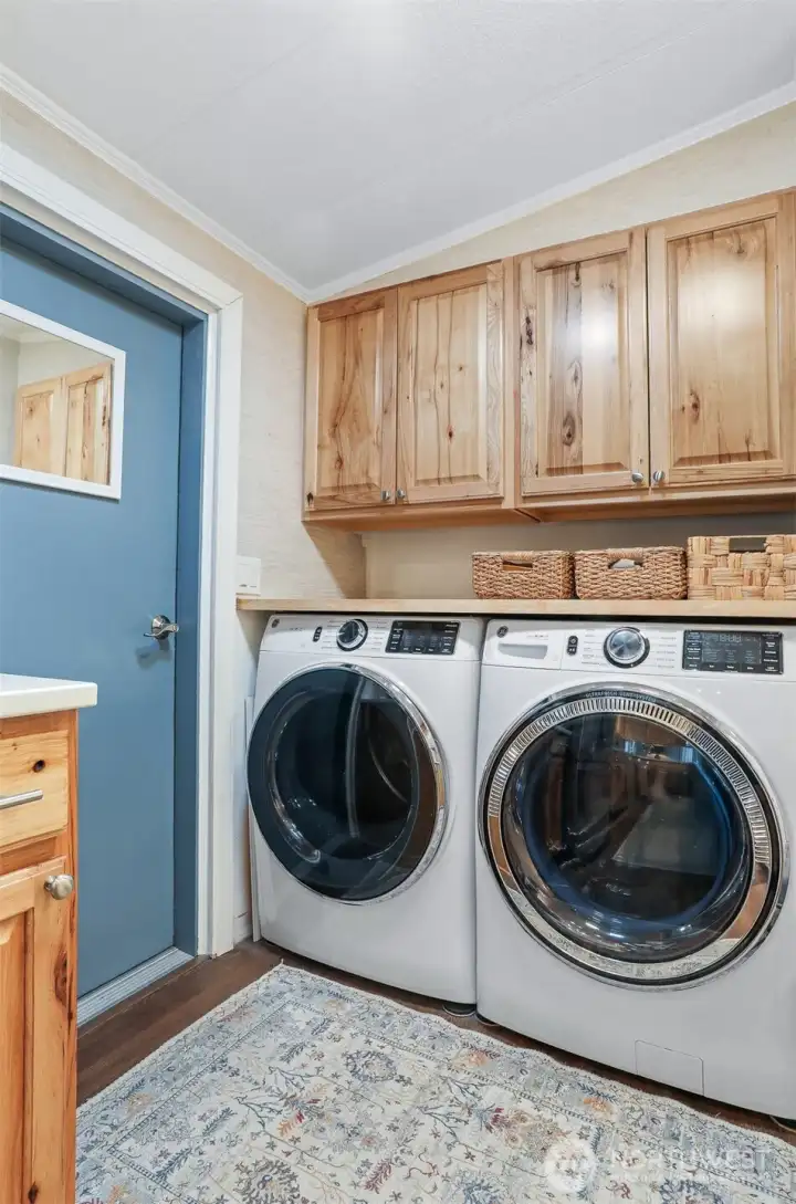 Laundry room with full size washer and dryer and hickory cabinets