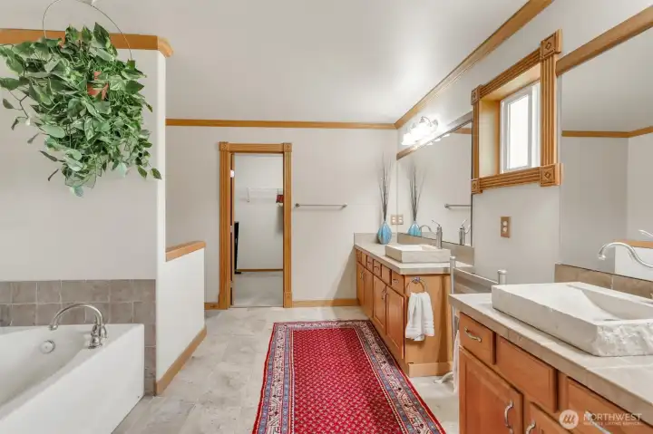 Comfort height sinks, a soaking tub and walk in shower in the primary bathroom