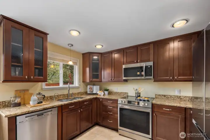 Kitchen with wood cabinetry, stainless steel appliances, and ample counter space. Designed for efficient use with good storage and workspace.