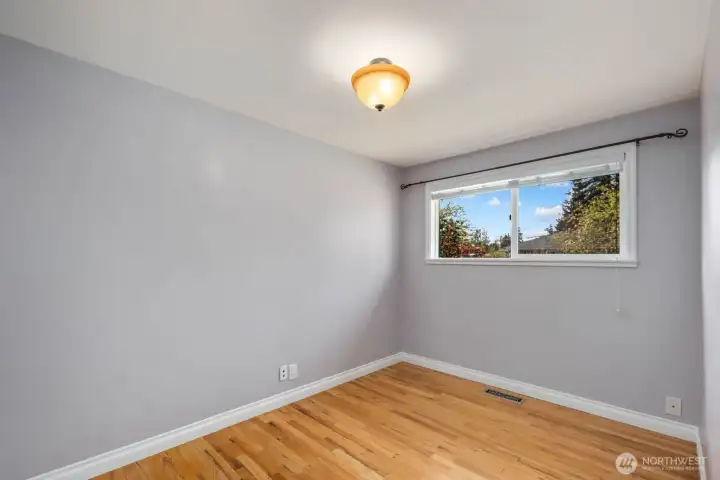 Additional room with hardwood floors, painted walls, and window for natural light. The flexible layout works well as a bedroom, home office, hobby room, or other everyday living space.