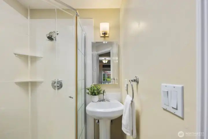 Bathroom with updated vanity, mirror, and tiled tub surround. Clean layout with practical fixtures and storage.