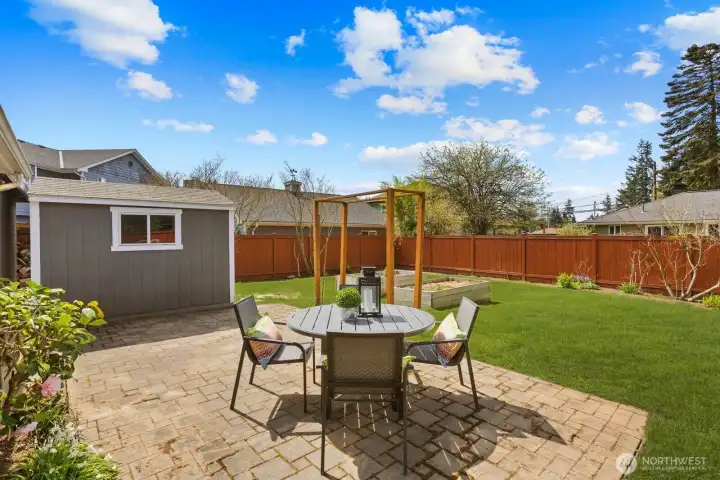 Backyard patio area with space for outdoor seating and dining. Fully fenced yard provides room for outdoor use and privacy.