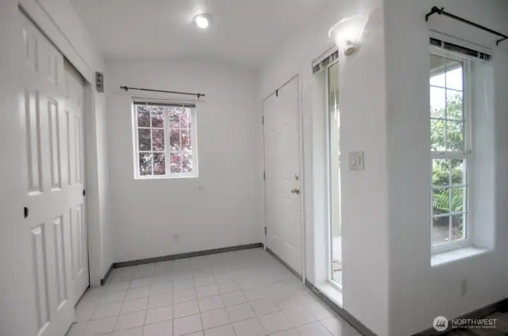 Bright tiled entry with coat closet
