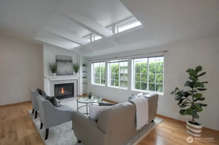 The living room is brightened by natural light that streams through this wall of windows