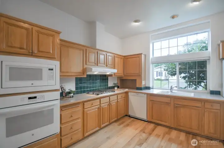 At the center of the home is this expansive kitchen with gas stovetop, oven, microwave, dishwasher, and refrigerator all included