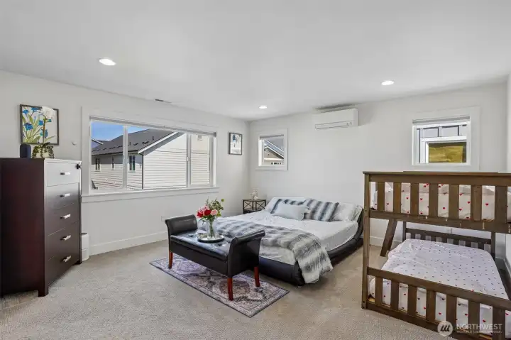 Spacious primary suite designed for comfort and relaxation with abundant natural light
