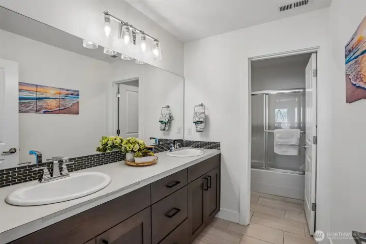 Shared upstairs bathroom features dual sinks for added convenience and functionality