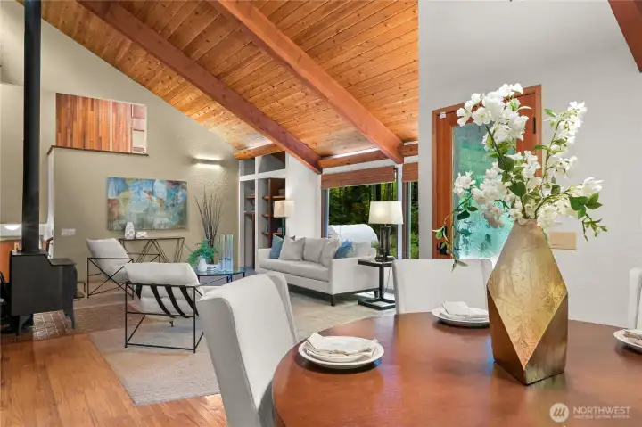 Dining leads to relaxing in the Living Room. Door behind the flowers takes you out to the lawn and gardens. Dining leads to relaxing in the Living Room. Door behind the flowers takes you out to the lawn and gardens.