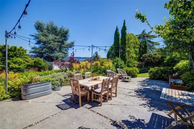 Dine al fresco on this sweet patio with evening lights. Yard features hydrangeas, lilies, hostas and lush mature hedges to provide the utmost privacy